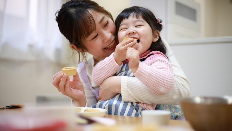 Madre y niña comen un dulce.