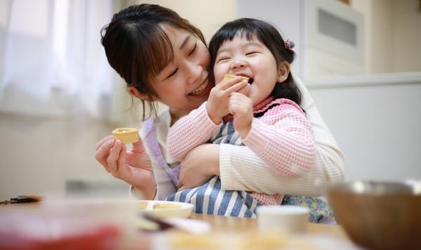 Madre y niña comen un dulce.
