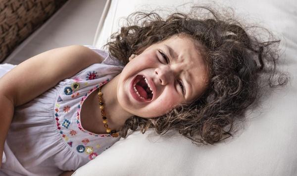 Young girl yelling on a pillow.