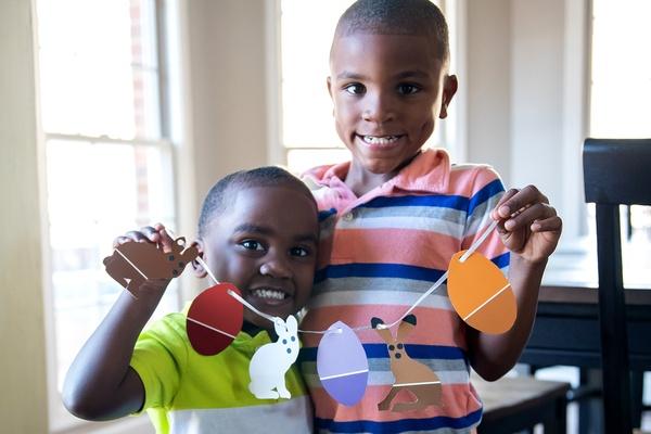 Two brothers hold their Easter bunny garland together.