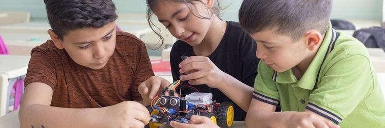 Three children working together to build a robot toy.