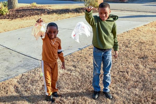 Two children use their parachutes.