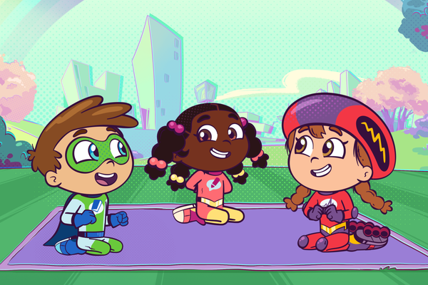 Super Why, Power Paige, and Wonder Red are sitting on a picnic blanket in the park.