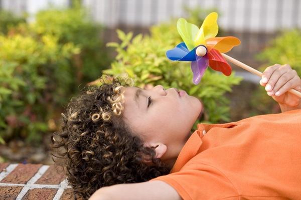 Child blowing on a pinwheel.