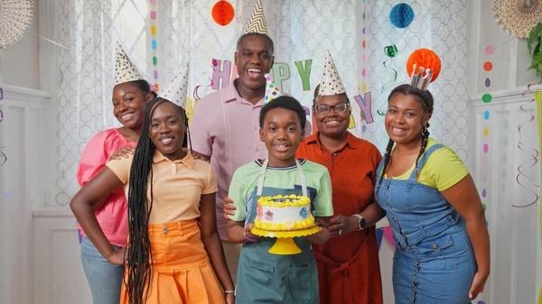 Image of a family gathered around a birthday cake.
