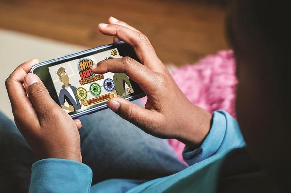 Child playing a Wild Kratts game on a cell phone.