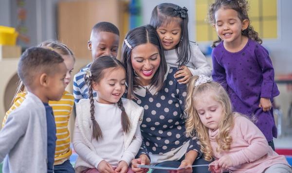 Group of children reading with their teacher.
