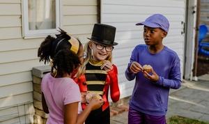 Children eating cupcakes and dressed in costumes.