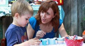 Parent and child making paper link chain at Daniel Tiger birthday party