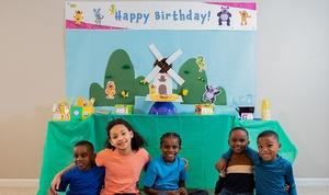 Kids sitting in front of party table.