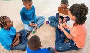 Kids sitting in a circle playing a game.