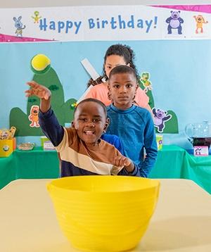 Three kids playing a toss game.