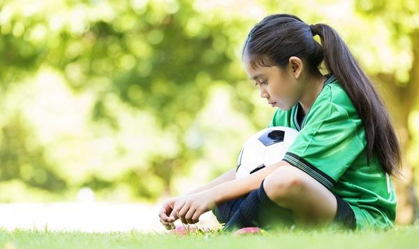 Image of a girl holding a soccer ball.