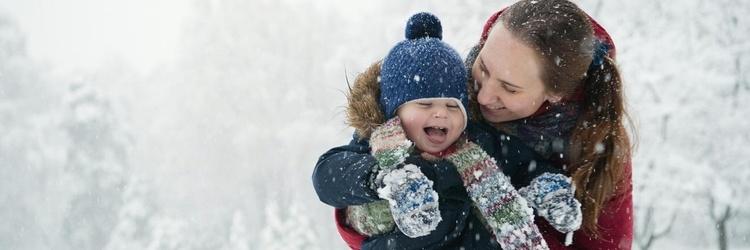 Mom and child playing in the snow.