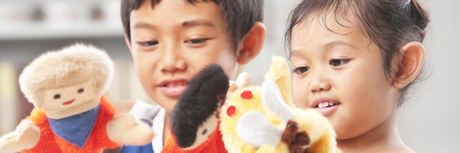 Image of two children playing with puppets.
