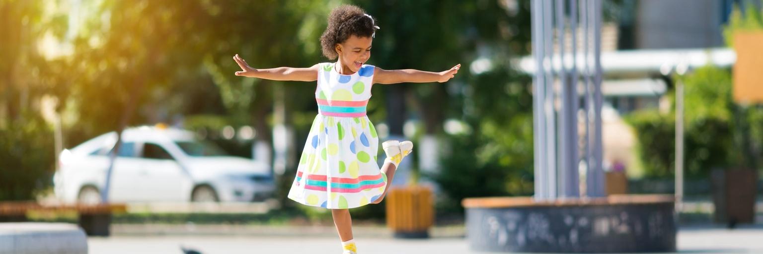 Image of little girl dancing outside.