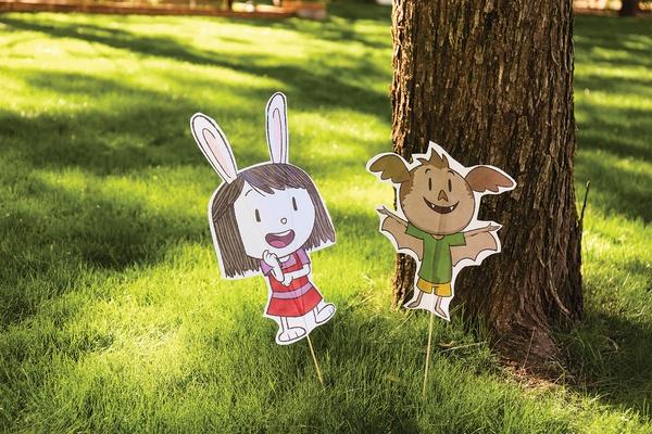 Two character cutouts poking out of the grass.
