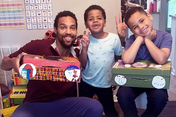Pierce Freelon y dos niños posan con sus BoomBox terminados.