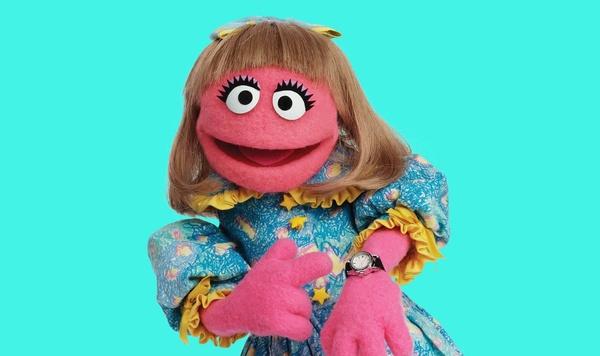Prairie Dawn Muppet character from Sesame Street pointing at her watch.