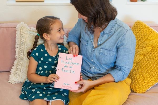 Una mamá y su hija con su libro sobre sus tradiciones familiares.
