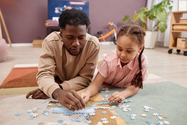 Parent and child doing a puzzle together.