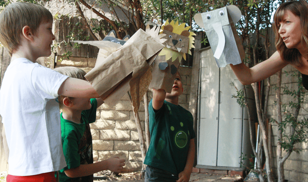 Children playing with their finished paper bag animal puppets.