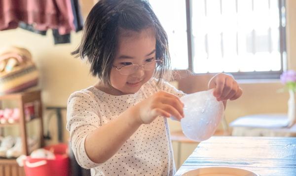 Image of little girl playing with slime.