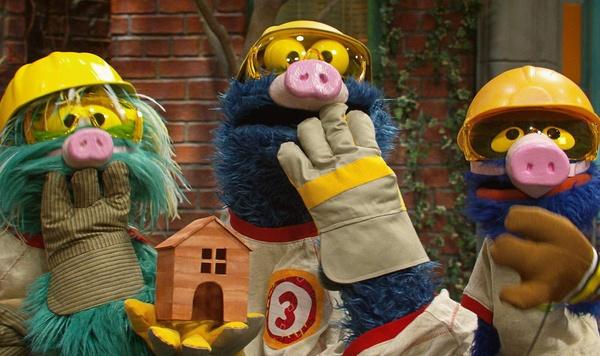 Rosita, Cookie Monster, and Grover holding their hands up to their mouths.
