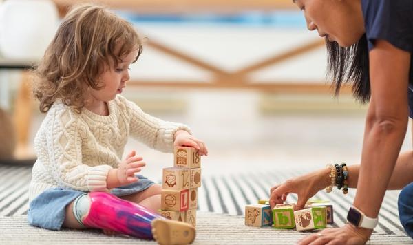 Young girl building a tower with blocks.