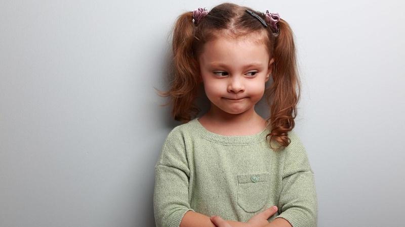 Imagen de una pequeña niña con una mirada frustrada en el rostro.