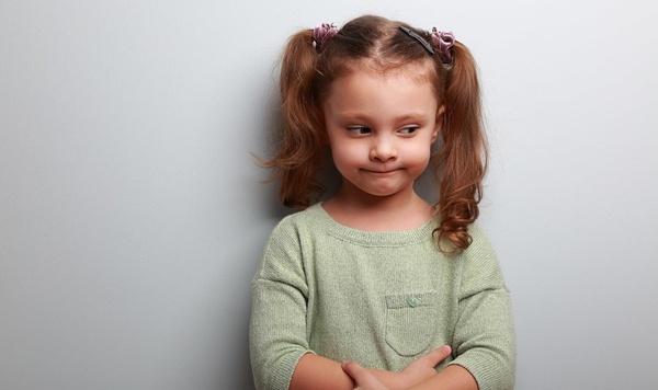 Imagen de una pequeña niña con una mirada frustrada en el rostro.