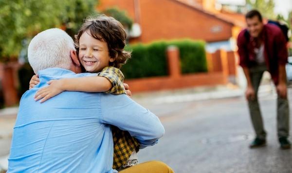 A child hugging his grandfather.