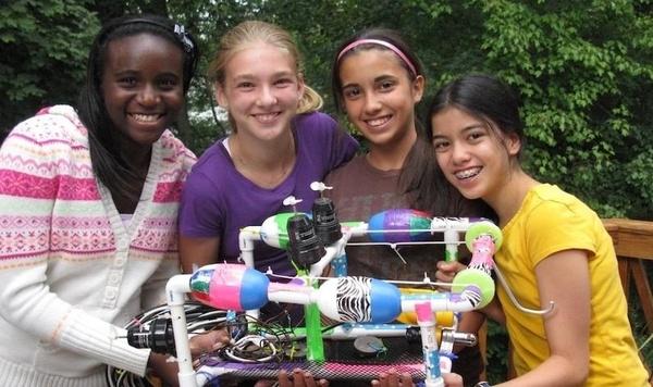 Image of girls standing next to their invention.