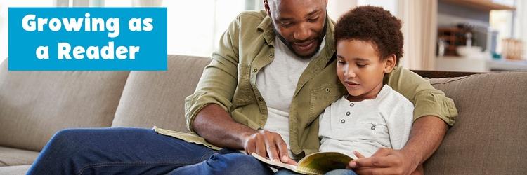 Father and son reading together on the couch.