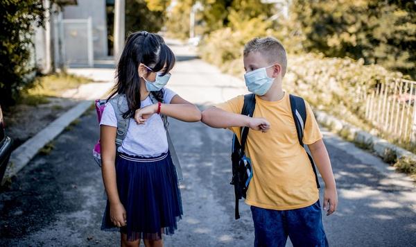 Two kids bumping elbows as a greeting.