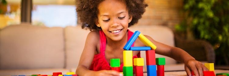 Little girl building with blocks.