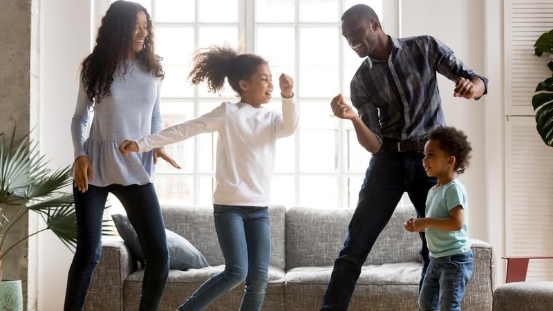 Imagen de una familia bailando juntos en el salón.