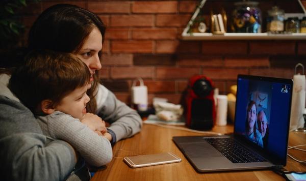 Image of mother and son video chatting with grandparents.
