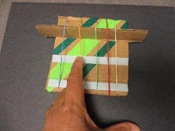 small instrument made of cardboard and rubberbands