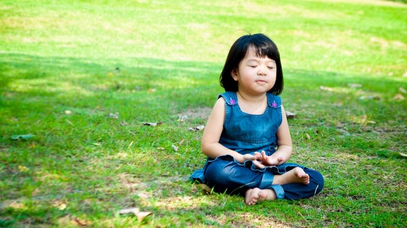 Young girl meditating outdoors.