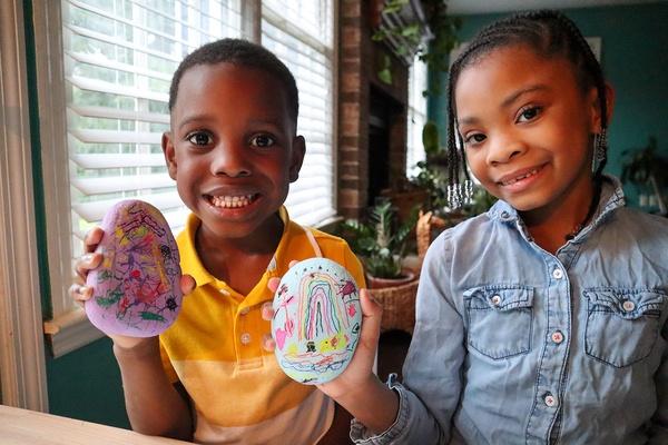 Two children showing their finished lucky rock art.