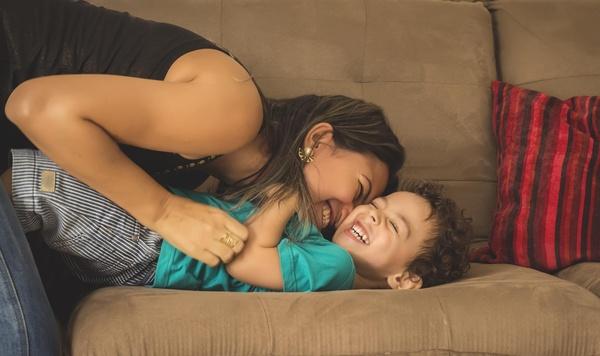 Image of mom and son laughing on the couch.