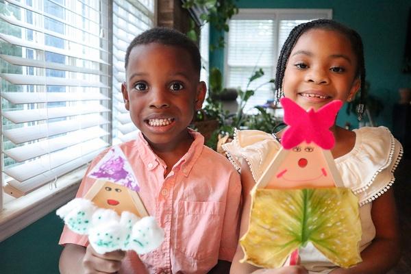 Two children hold their homemade popsicle stick gnomes.