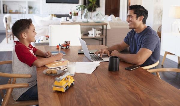 Image of father and son at kitchen table working.