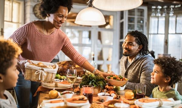 Family eats Thanksgiving meal together.