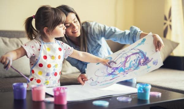 Image of mother and daughter painting together.