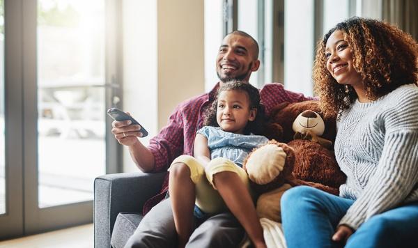 Image of daughter watching television with her parents.