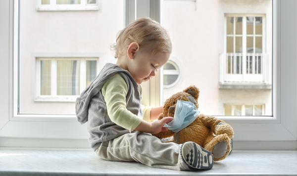 Image of young boy playing with teddy bear.