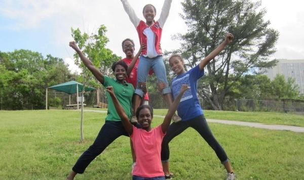 Girls forming a cheerleading pyramid.